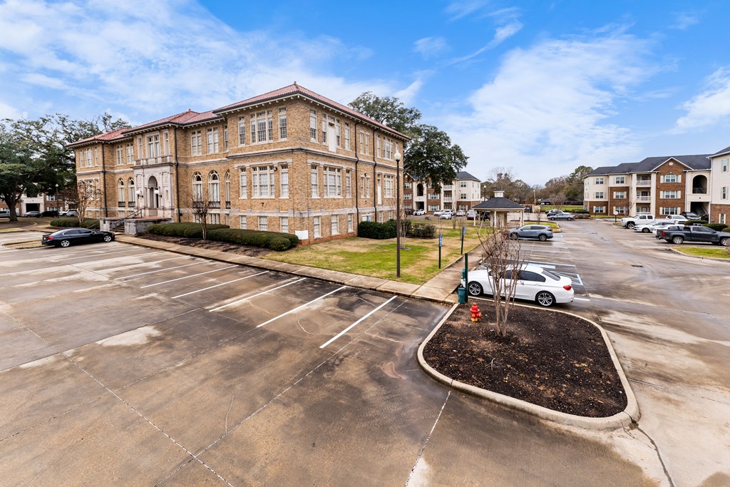 a large brick building at the corner of a parking lot
