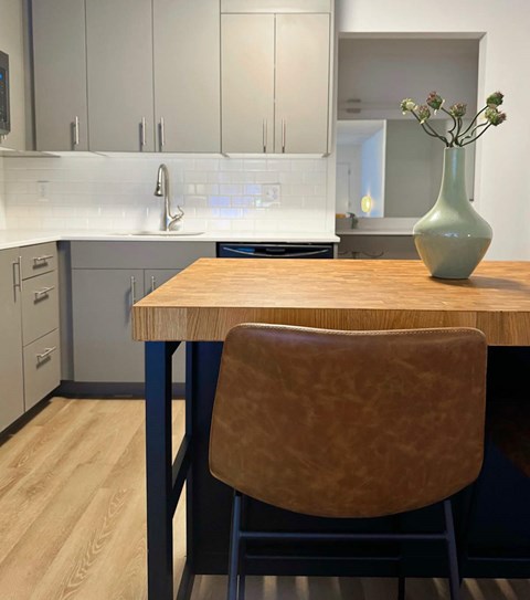 A kitchen with a wooden table and a brown chair.