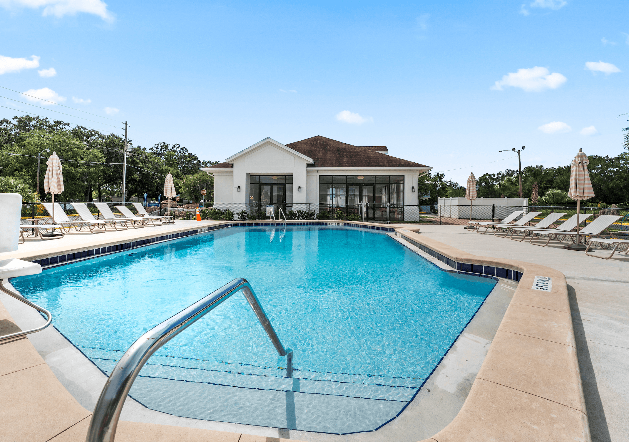 A large swimming pool in front of a building with a white roof at The Teale Siesta Lago in Kissimmee, FL, 34746