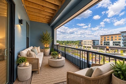 A balcony with a couch, chairs and potted plants.