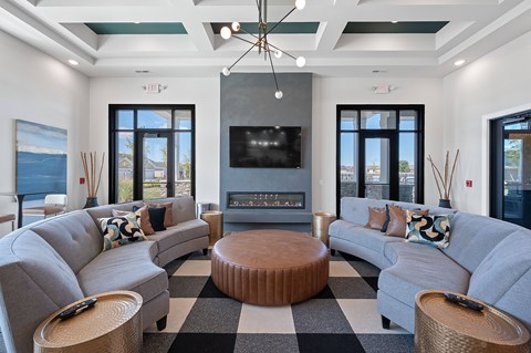 A modern living room with grey couches and a black and white checkered rug.