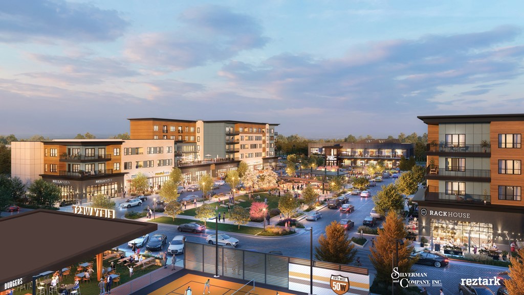 A city street with cars and buildings with a sign at The District at Deerfield Residences Apartments, Mason, OH, 45040