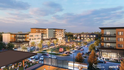 A city street with cars and buildings with a sign at The District at Deerfield Residences Apartments, Mason, OH, 45040