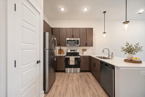 A modern kitchen with wooden cabinets and stainless steel appliances.