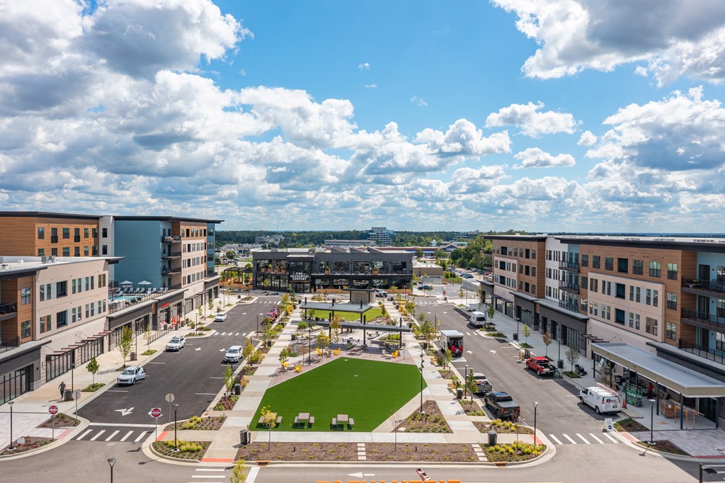 A view of a city street with a green park in the middle.