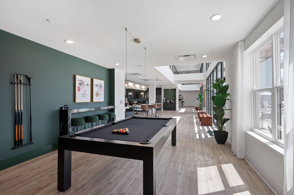 A room with a pool table and a green wall.