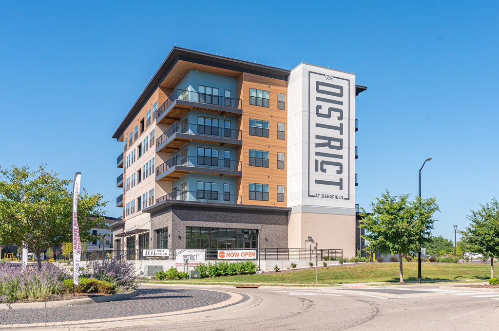 A multi-story building with a sign that reads "District" on the side.