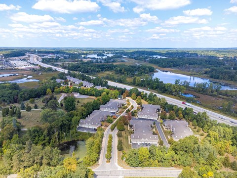 A bird's eye view of a residential area with a road leading to a large house.