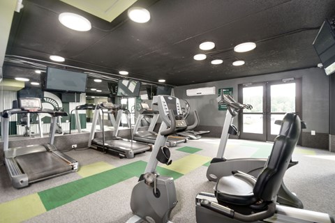 A gym with treadmills, exercise bikes and other equipment.