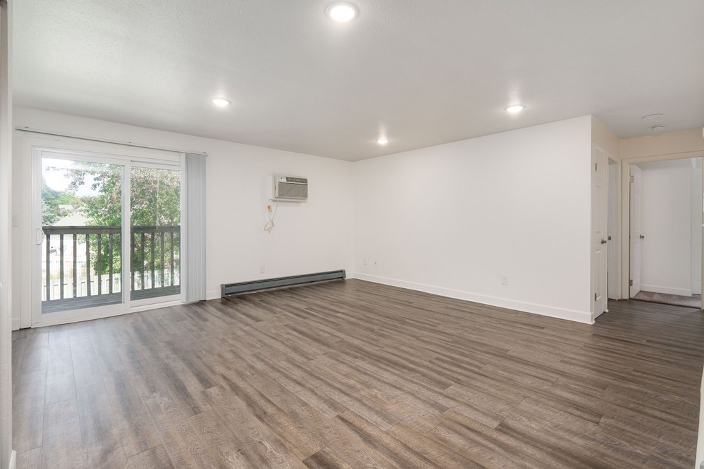 A room with wooden flooring and white walls.