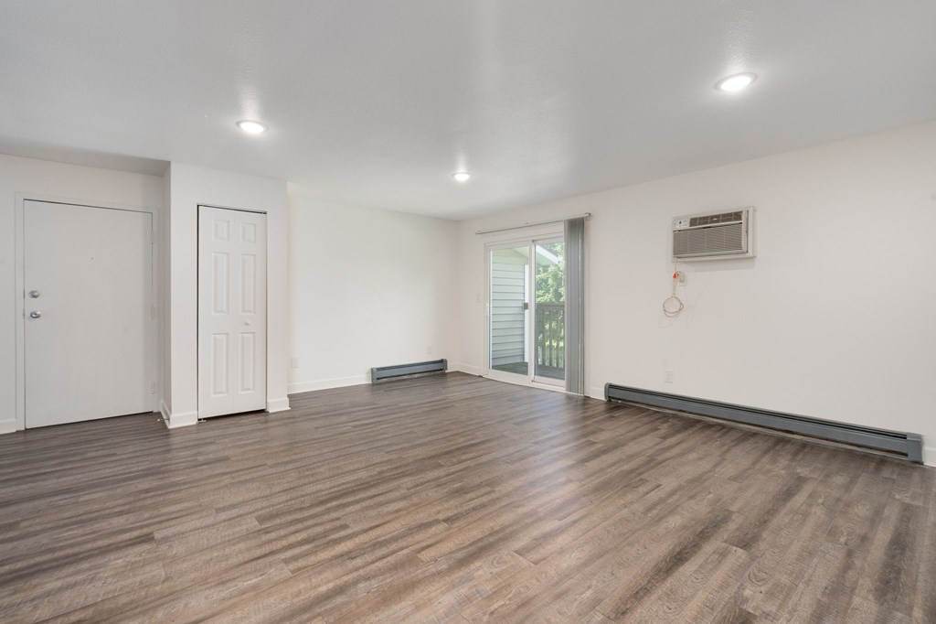 A room with wooden flooring and white walls.