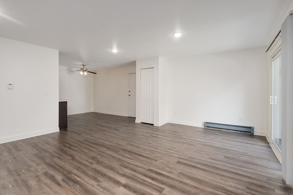 A room with wooden flooring and a ceiling fan.