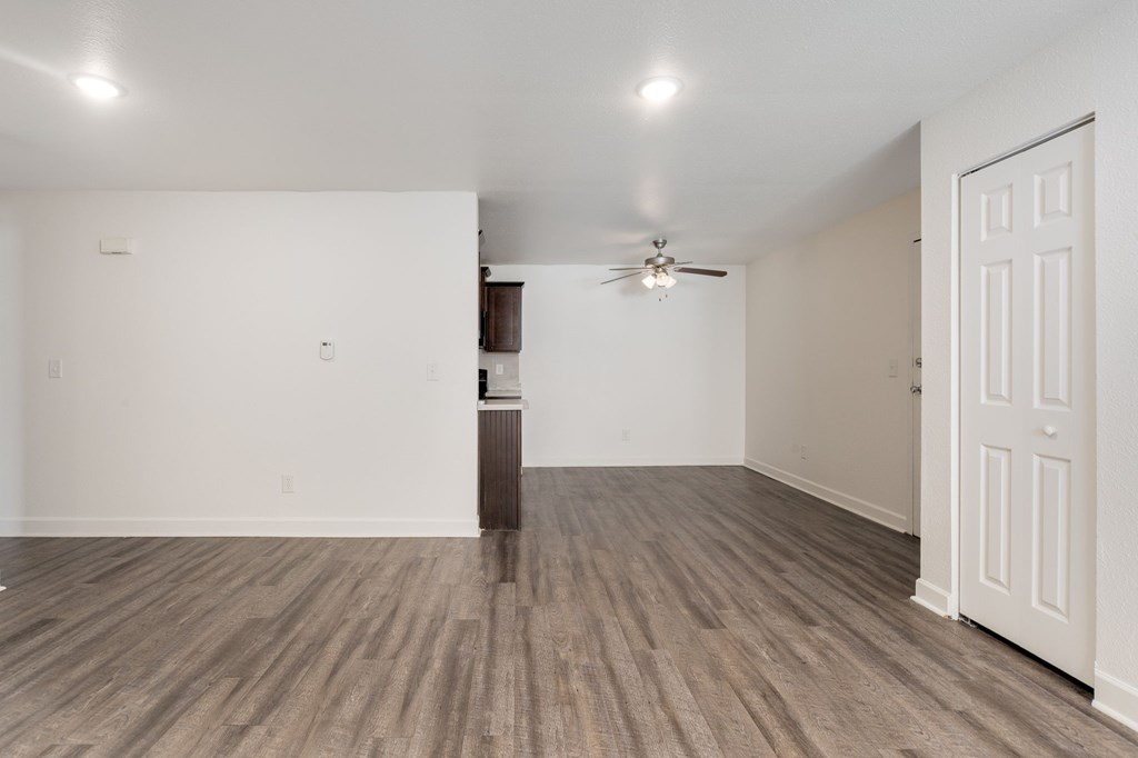 A room with a ceiling fan and a door.