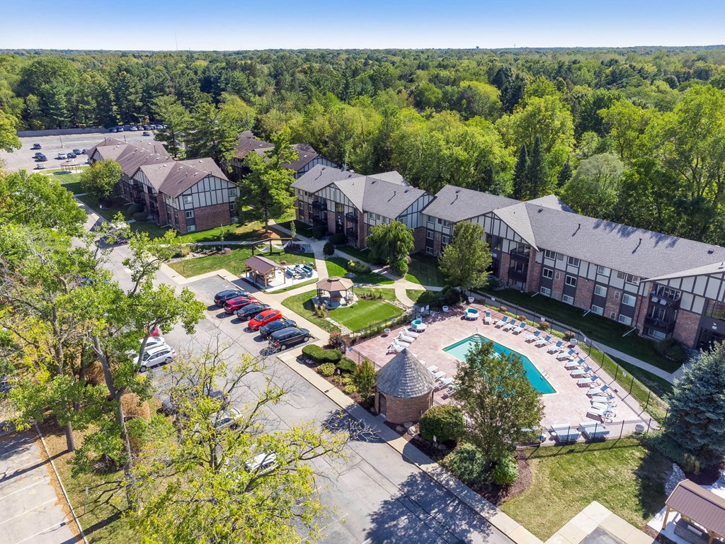 A large building complex with a pool and a parking lot.