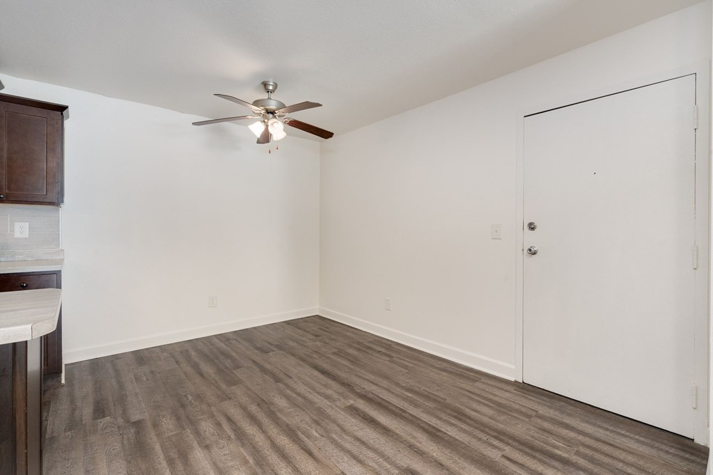 A room with a ceiling fan and a white door.