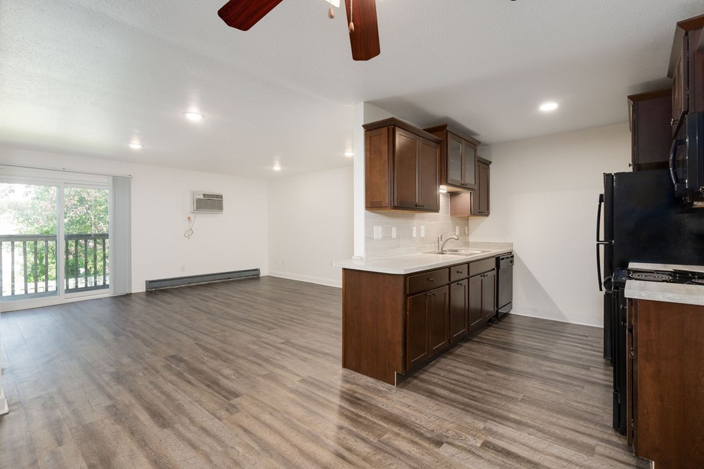 A kitchen with wooden cabinets and a black refrigerator.