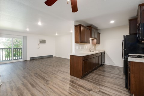 A kitchen with wooden cabinets and a black refrigerator.