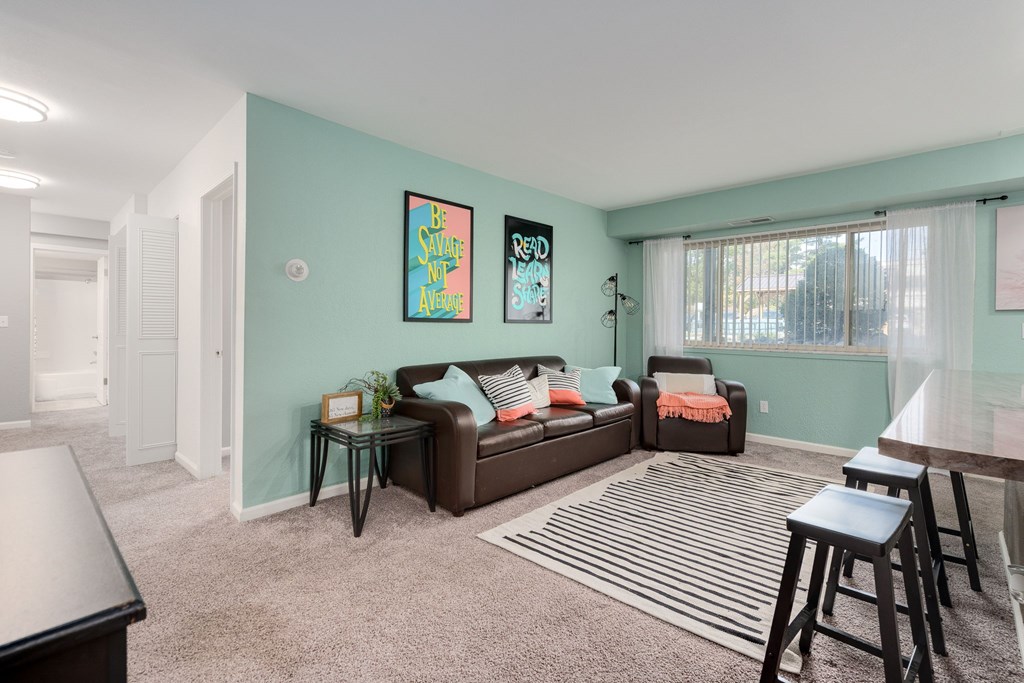 A living room with a brown couch and two chairs.