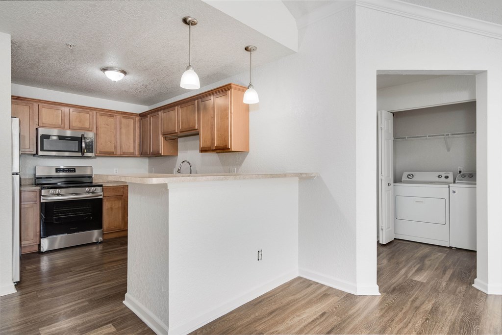 A kitchen with wooden cabinets and a white island.