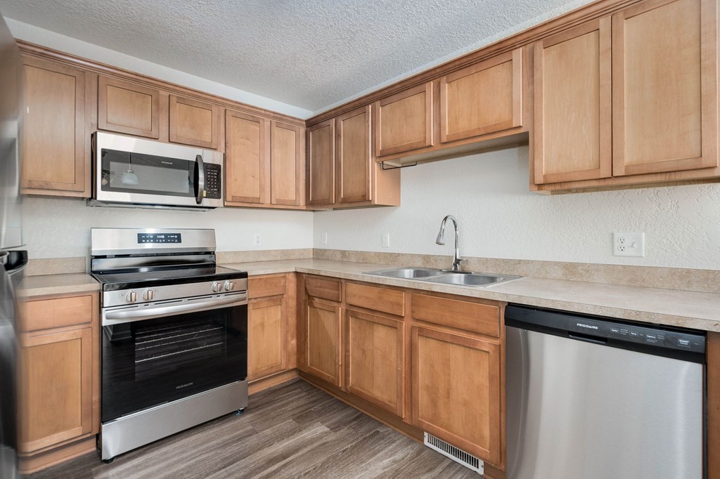 A kitchen with wooden cabinets and stainless steel appliances.