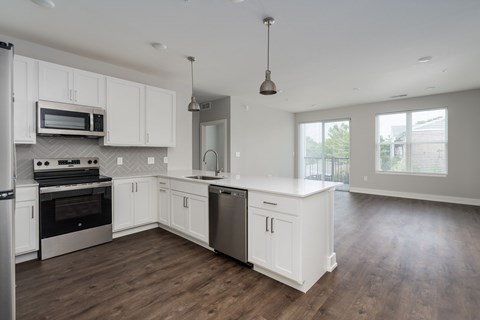 A modern kitchen with white cabinets and stainless steel appliances.
