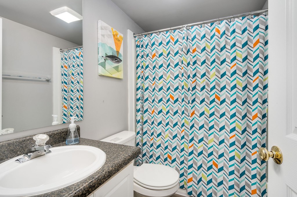 A bathroom with a patterned shower curtain.