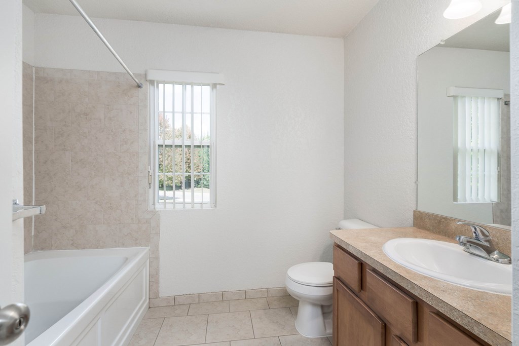 A white bathroom with a tub, toilet and sink.
