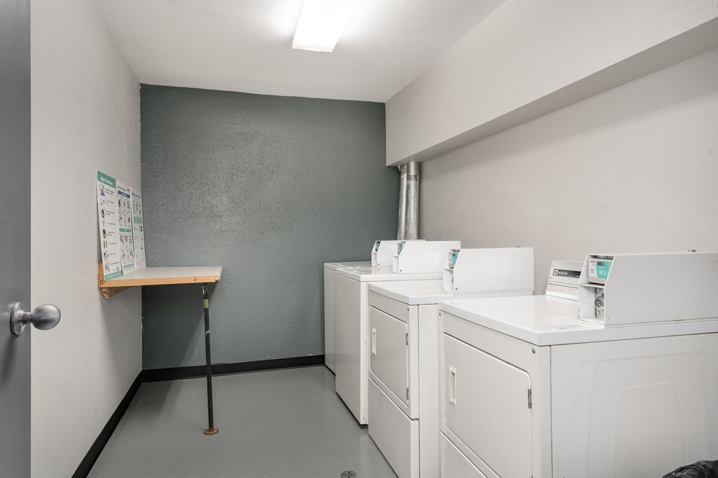 A laundry room with washers and dryers.