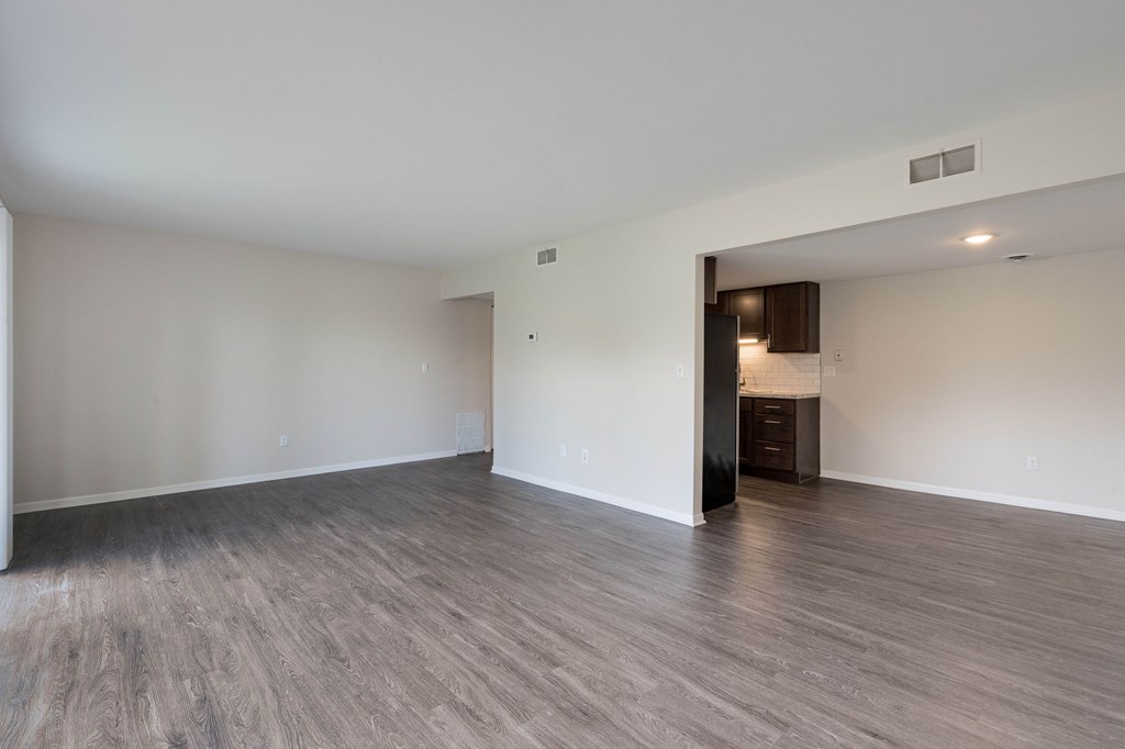 A room with a wooden floor and a white wall.