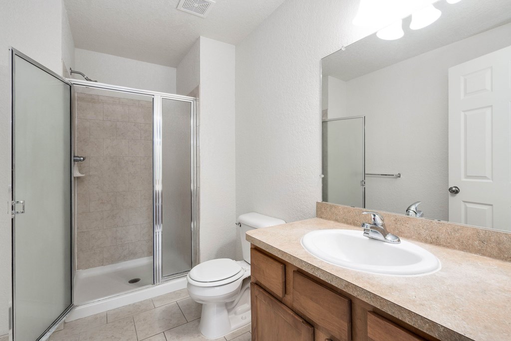 A bathroom with a toilet, sink, and shower.