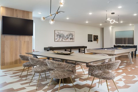 A modern dining room with a large table and chairs.