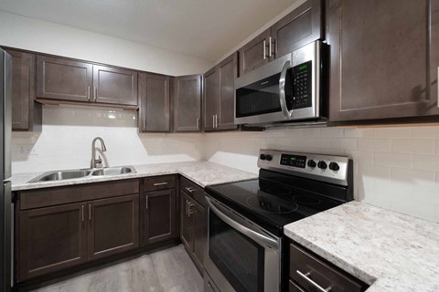 a kitchen with stainless steel appliances and marble counter tops