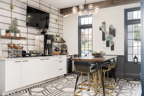 A kitchen with a patterned floor and a dining table with chairs.