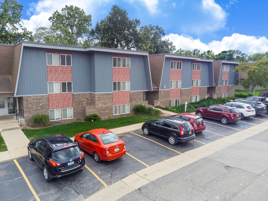 A parking lot with cars and a building in the background.