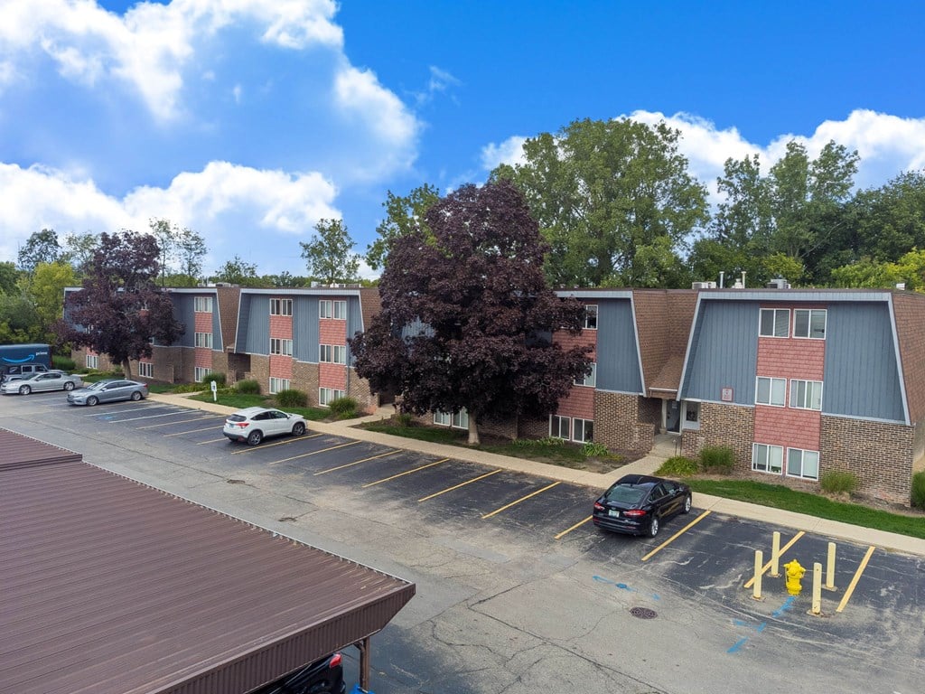 A parking lot with cars and a building in the background.