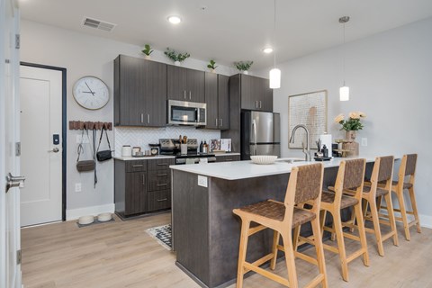 A kitchen with wooden chairs and a white counter.