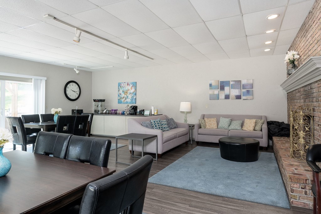A living room with a fireplace and a dining table.