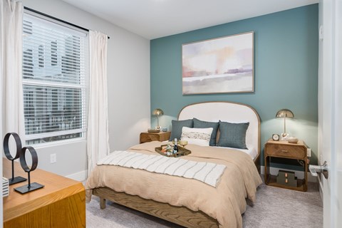 A bedroom with a large bed and a painting on the wall.