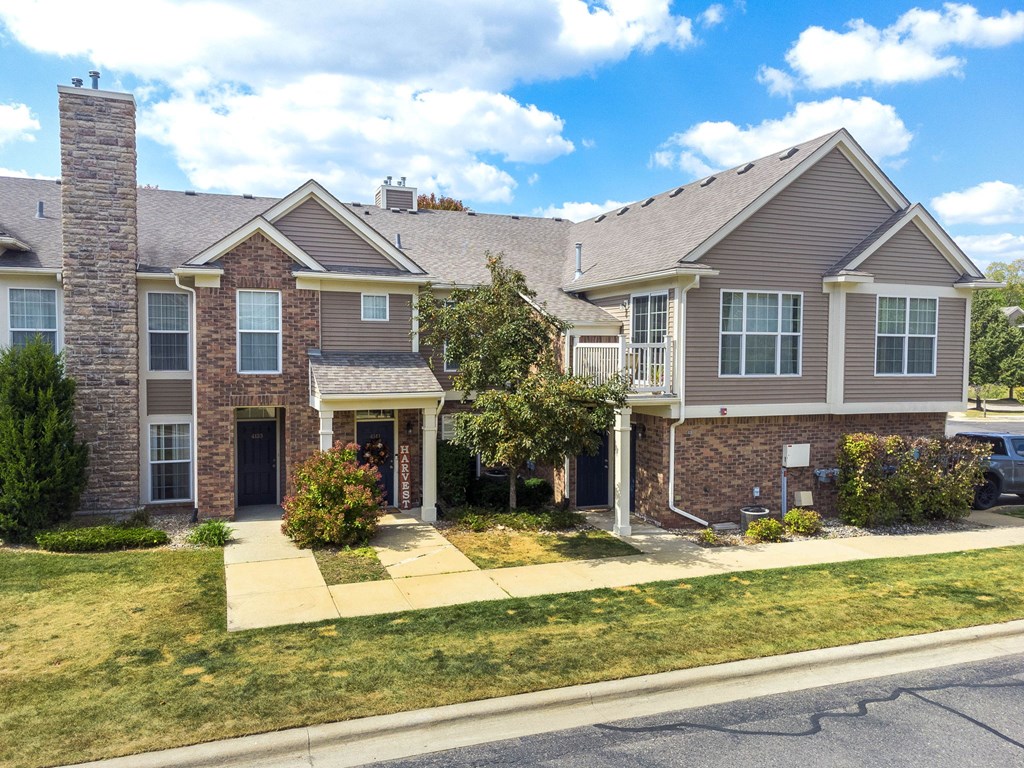 A house with a brick facade and a stone chimney.