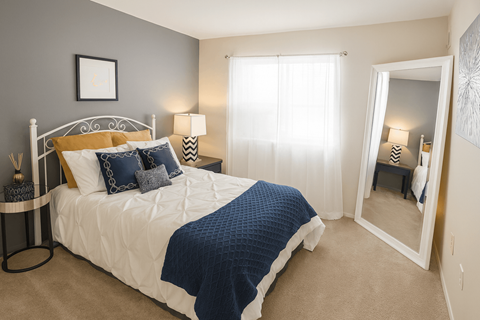 A bedroom with a white bed and blue bedding.