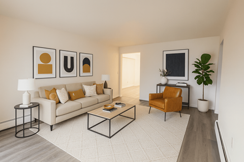A living room with a white couch, a coffee table, and a chair.