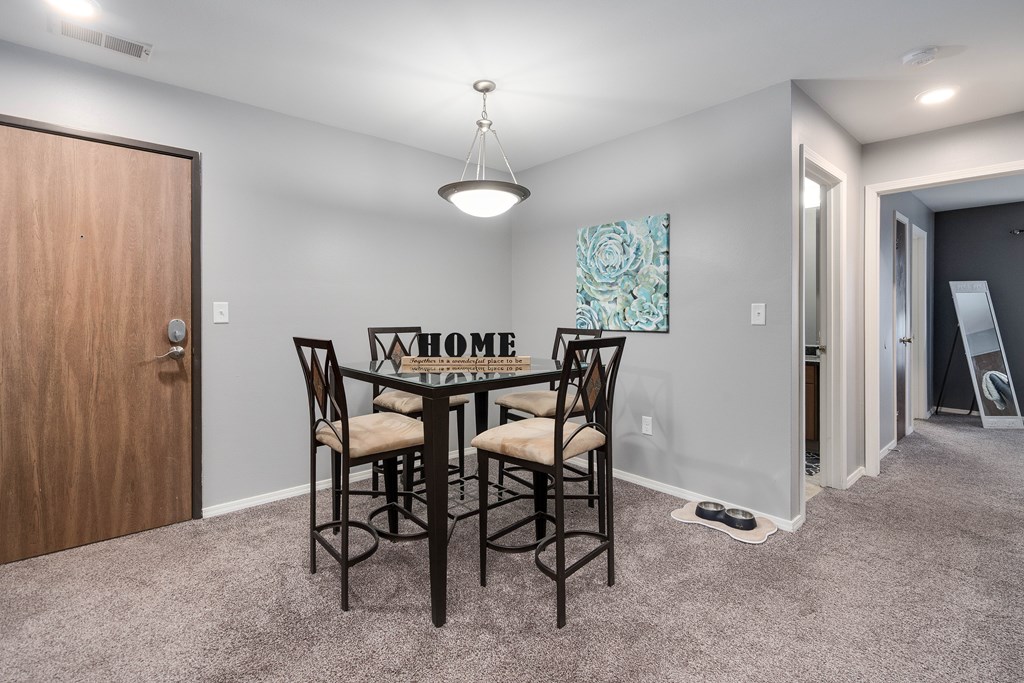 A dining room with a table and chairs.