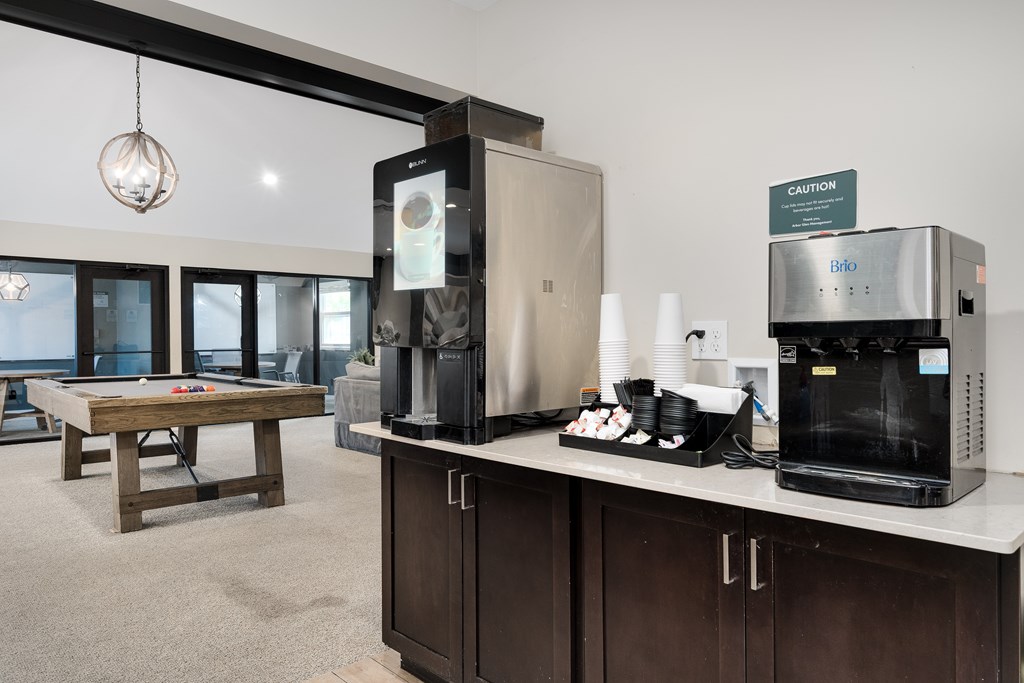 A modern kitchen with a wooden table and a coffee machine.