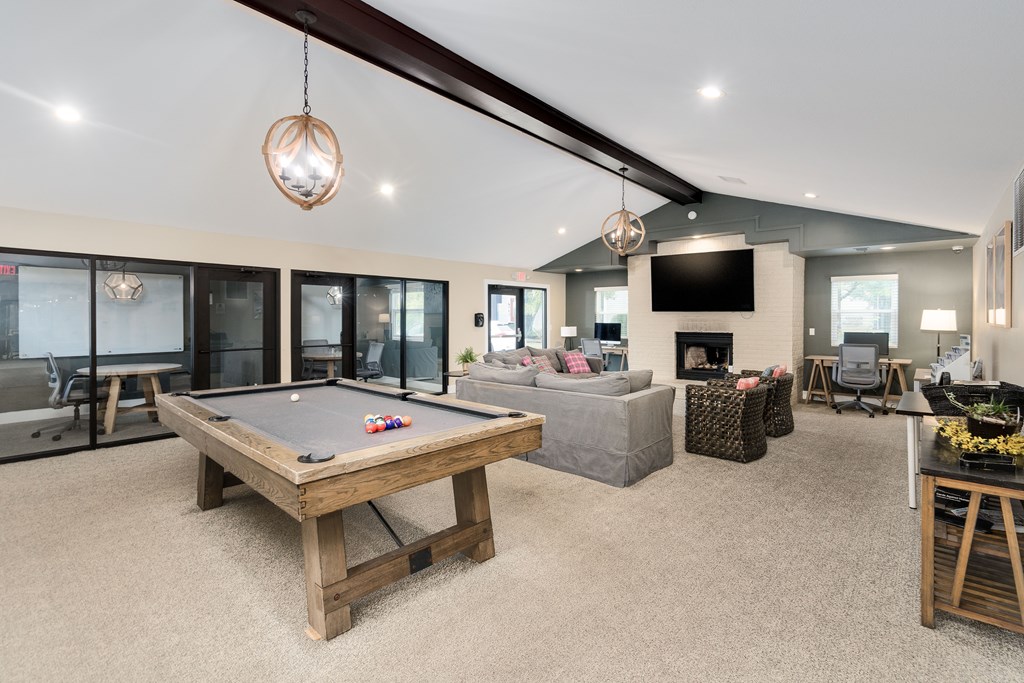 A billiard table is in the middle of a living room.
