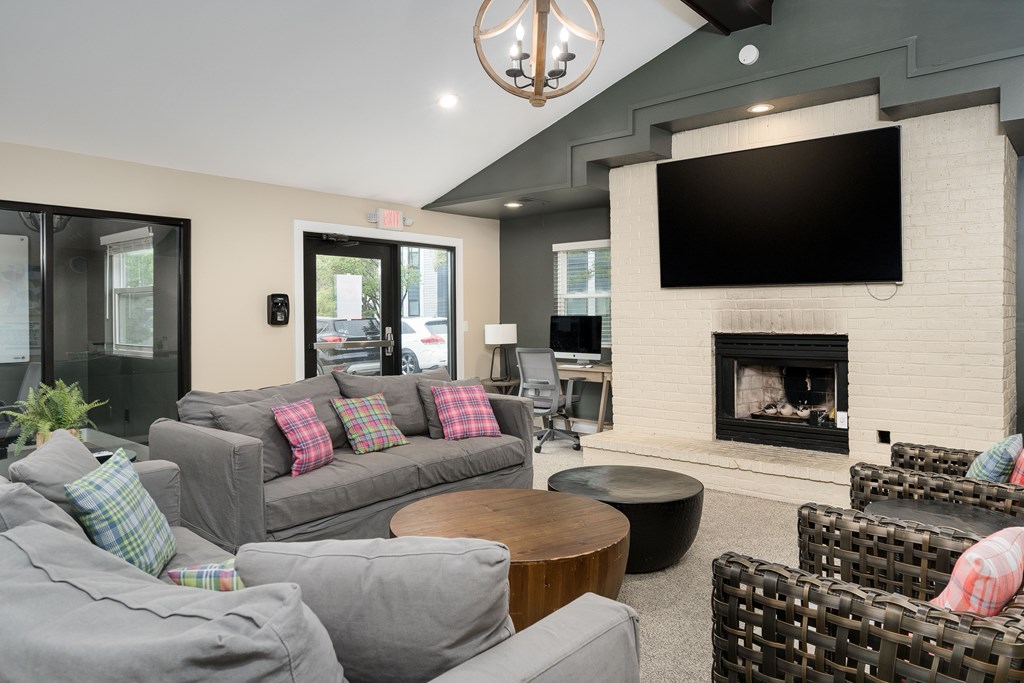 A living room with a grey couch and a fireplace.