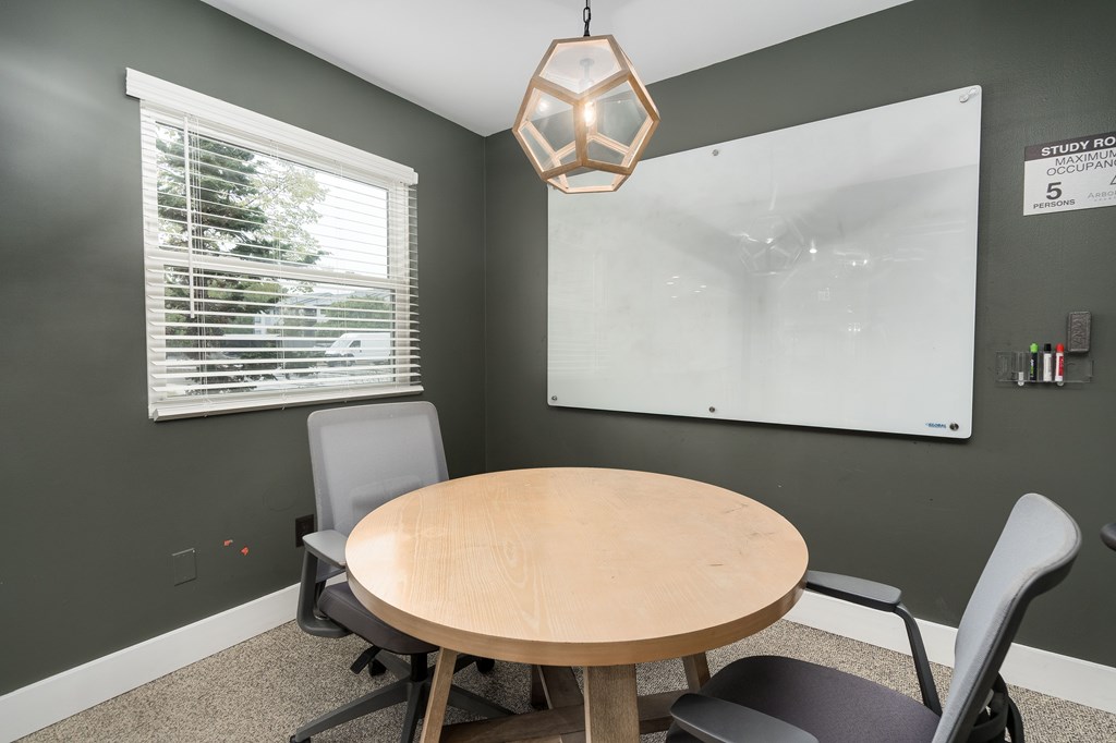 A conference room with a whiteboard and a table.