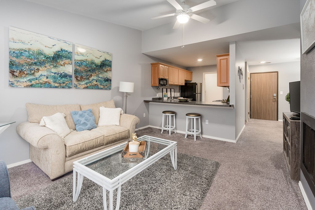 A living room with a couch, a coffee table, and a painting on the wall.