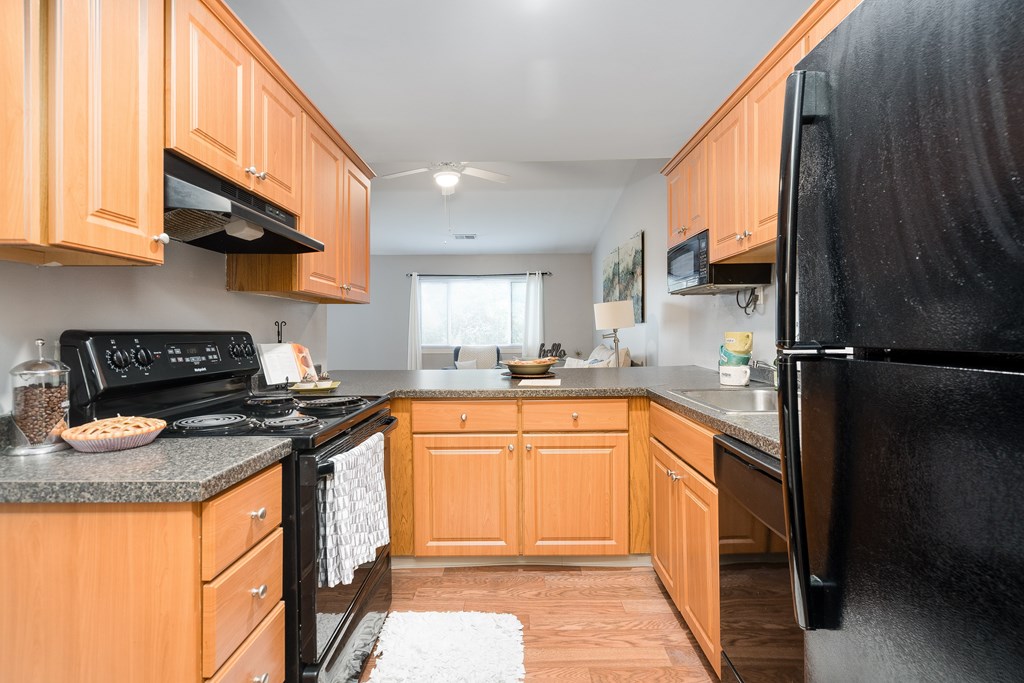 A kitchen with wooden cabinets and black appliances.
