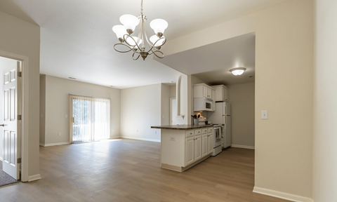 A kitchen with white cabinets and a chandelier.
