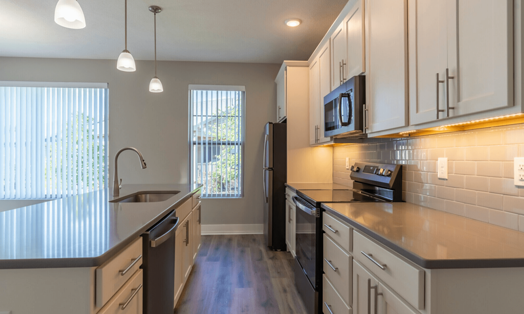 A kitchen with a black refrigerator and a black stove.